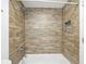 Updated shower featuring wood tile and built-in shampoo niche in a modern design at 6165 Carrier Dr # 1603, Orlando, FL 32819