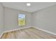 Serene bedroom with neutral walls, wood-look floors, and a bright window offering a pleasant view at 68 Water Track Loop, Ocala, FL 34472