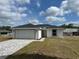 Charming single-story home featuring a two-car garage, and a well-manicured lawn on a sunny day at 68 Water Track Loop, Ocala, FL 34472