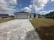 Inviting single-story residence featuring a two-car garage and a charming walkway, set against a blue sky backdrop at 68 Water Track Loop, Ocala, FL 34472