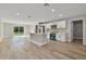 Bright, open kitchen featuring an island, modern appliances, white cabinets, and wood-look floors at 68 Water Track Loop, Ocala, FL 34472