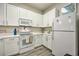 Well-lit kitchen boasting white appliances, ample cabinet space, and sleek countertop at 702 Gran Bahama Blvd, Davenport, FL 33897