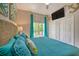 Comfortable main bedroom with a wicker headboard, turquoise bedding, and a patio view at 702 Gran Bahama Blvd, Davenport, FL 33897