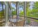 Relaxing screened patio with a table and two chairs overlooking a lush green yard at 702 Gran Bahama Blvd, Davenport, FL 33897