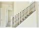 Elegant staircase with wrought iron spindles, a white banister, and carpeted steps leading to the upper level at 7562 Sunflower Cir, Kissimmee, FL 34747