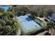 Aerial view of a blue and green tennis court surrounded by trees at 7562 Sunflower Cir, Kissimmee, FL 34747