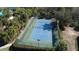 Aerial view of a blue and green tennis court with trees surrounding at 7562 Sunflower Cir, Kissimmee, FL 34747