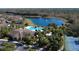 Aerial view of a pool, tennis courts, community buildings, landscaping, and a pond at 7564 Sunflower Cir, Kissimmee, FL 34747