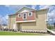 Side exterior view of a two-story townhome featuring a manicured lawn at 7564 Sunflower Cir, Kissimmee, FL 34747