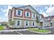 Well-maintained townhouse with tan and red siding, white trim, parking and green space at 7564 Sunflower Cir, Kissimmee, FL 34747