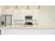 Bright kitchen boasts white cabinets, granite countertops, stainless steel appliances, and stylish pendant lighting at 7564 Sunflower Cir, Kissimmee, FL 34747