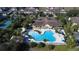 Aerial view of a clover-shaped pool with a clubhouse, lounge chairs, and lush tropical landscaping in a vacation community at 7564 Sunflower Cir, Kissimmee, FL 34747