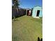 A large, green backyard with a storage shed with lawn equipment, surrounded by a wood fence at 804 Carrousel Ln, Kissimmee, FL 34759