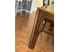 Close up view of decorative dark wood dining table leg with light grey barstools in background at 804 Carrousel Ln, Kissimmee, FL 34759
