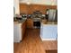 Functional kitchen featuring stainless steel appliances, warm wood cabinetry and hardwood floors at 804 Carrousel Ln, Kissimmee, FL 34759