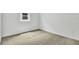 Cozy bedroom featuring neutral carpeting, white walls, and a bright window at 804 Lake Dell Rd, Dundee, FL 33838