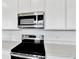 Close-up of stainless steel microwave and oven with white quartz countertops at 804 Lake Dell Rd, Dundee, FL 33838