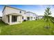 Spacious backyard with covered patio, lush green grass, and contemporary home design at 808 Lake Dell Rd, Dundee, FL 33838