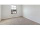 Empty bedroom with carpet and one window overlooking a residential house at 808 Lake Dell Rd, Dundee, FL 33838