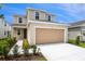 Charming two-story home featuring an attached two-car garage, manicured lawn, and beautiful landscaping at 808 Lake Dell Rd, Dundee, FL 33838
