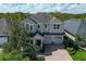 Overhead view of a well-manicured home with three-car garage, brick driveway, and serene tree-lined backyard at 8228 Randal Park Blvd, Orlando, FL 32832