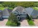 Aerial view showcasing the home's layout, three-car garage, and brick driveway surrounded by lush greenery at 8228 Randal Park Blvd, Orlando, FL 32832