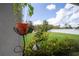 Lush backyard with manicured lawn, mature landscaping, and a glimpse of the play structure in the distance at 8228 Randal Park Blvd, Orlando, FL 32832
