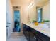 Bathroom with double sink, dark cabinets, white countertop, and view to another room at 8228 Randal Park Blvd, Orlando, FL 32832