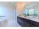 Bathroom featuring double vanity with quartz countertops, shower with tub and natural light at 8228 Randal Park Blvd, Orlando, FL 32832