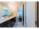 Bathroom with double sink, dark cabinets, white countertop, and view to another room at 8228 Randal Park Blvd, Orlando, FL 32832