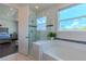 Bathroom featuring a tiled shower and soaking tub, with bedroom view at 8228 Randal Park Blvd, Orlando, FL 32832