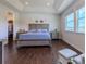 Bright bedroom featuring tray ceilings, hardwood floors, large windows, and a walk-in closet at 8228 Randal Park Blvd, Orlando, FL 32832