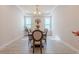 Bright dining room featuring wood-look tile flooring, modern chandelier and tray ceiling at 8228 Randal Park Blvd, Orlando, FL 32832