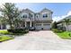 Lovely home with three-car garage, brick-paved driveway and walkway, complemented by lush landscaping at 8228 Randal Park Blvd, Orlando, FL 32832