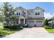 Charming two-story home with a three-car garage, brick-paved driveway, and manicured landscaping at 8228 Randal Park Blvd, Orlando, FL 32832