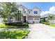 Beautiful two-story home featuring a brick-paved driveway, well-maintained lawn, and a three-car garage at 8228 Randal Park Blvd, Orlando, FL 32832