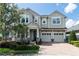 Attractive two-story home with a three-car garage, brick-paved driveway, and a welcoming front porch at 8228 Randal Park Blvd, Orlando, FL 32832
