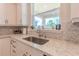 Modern kitchen sink with a view, marble countertops and stylish backsplash at 8228 Randal Park Blvd, Orlando, FL 32832