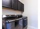 Laundry room with modern dark gray washer and dryer and dark upper cabinets at 8228 Randal Park Blvd, Orlando, FL 32832
