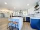 Open kitchen with seating at island, modern appliances, and custom cabinets in a neutral color palette at 905 W 11Th Ave, Mount Dora, FL 32757