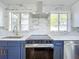 Modern kitchen featuring stainless steel appliances, range hood, custom cabinets, and designer backsplash at 905 W 11Th Ave, Mount Dora, FL 32757