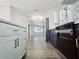 Modern kitchen with stainless steel appliances, white cabinetry and a view to the living room at 905 W 11Th Ave, Mount Dora, FL 32757