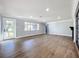 Spacious living room with wood floors, fireplace, and large windows for natural light at 905 W 11Th Ave, Mount Dora, FL 32757