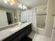 Bright bathroom with double sinks, granite countertops, and a bathtub with tiled shower at 9055 Dogleg Dr, Davenport, FL 33896