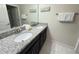 Bright bathroom with double sinks, granite countertops, and white tile flooring at 9055 Dogleg Dr, Davenport, FL 33896