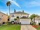 Charming two-story home with a well-manicured lawn, two-car garage, and a beautiful palm tree at 997 Lake Berkley Dr, Kissimmee, FL 34746