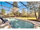 Relaxing screened-in pool and spa with outdoor seating overlooks a large, well-maintained backyard at 997 Lake Berkley Dr, Kissimmee, FL 34746