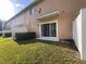 A view of the townhome backyard featuring healthy green lawn, shrubs, and patio at 10116 Shadow Leaf Ct, Orlando, FL 32825