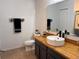Bathroom featuring black faucet, wood counter, large mirror, and tiled floors at 10116 Shadow Leaf Ct, Orlando, FL 32825