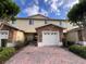 Exterior shows the home's garage with brick and stone accents, landscaping, and charming covered entryway at 10116 Shadow Leaf Ct, Orlando, FL 32825